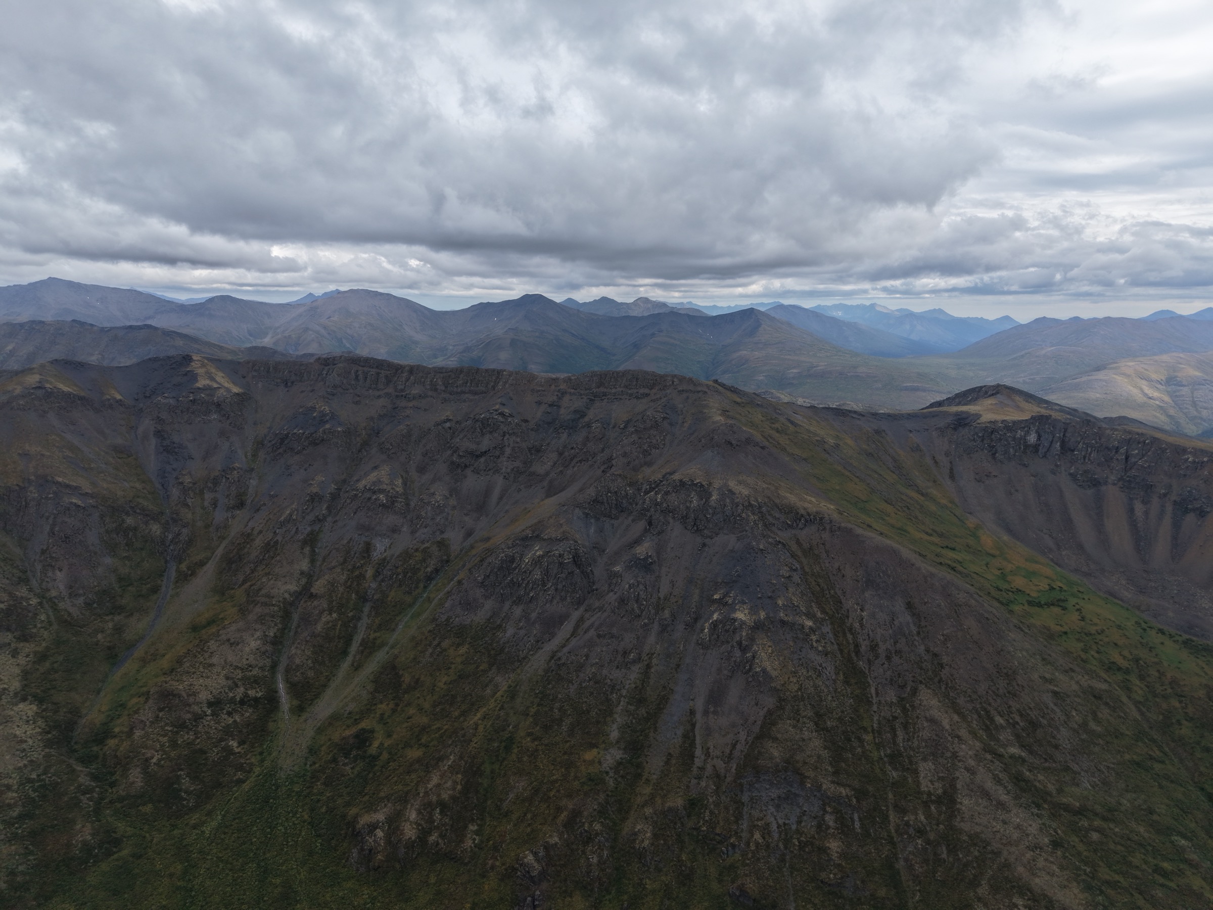 The opposite ridge along the horseshoe valley, with bare stone summits rising above long scree slopes.