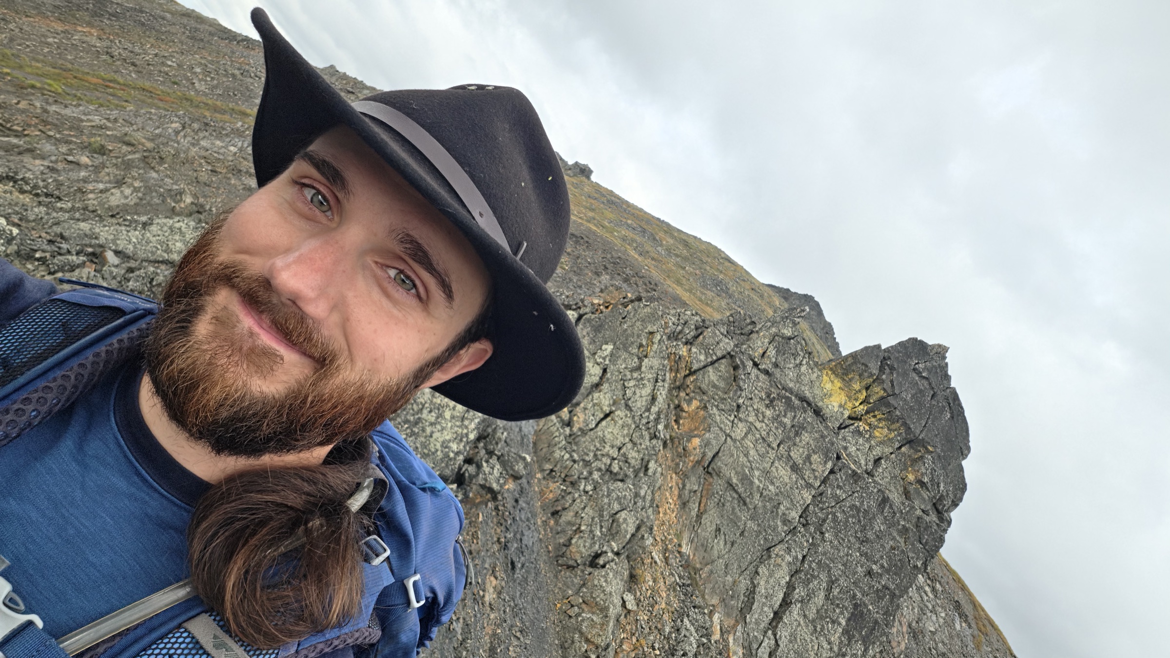 Self portrait on the ridge in scarf, toque and windbreaker, with one remaining spire behind.