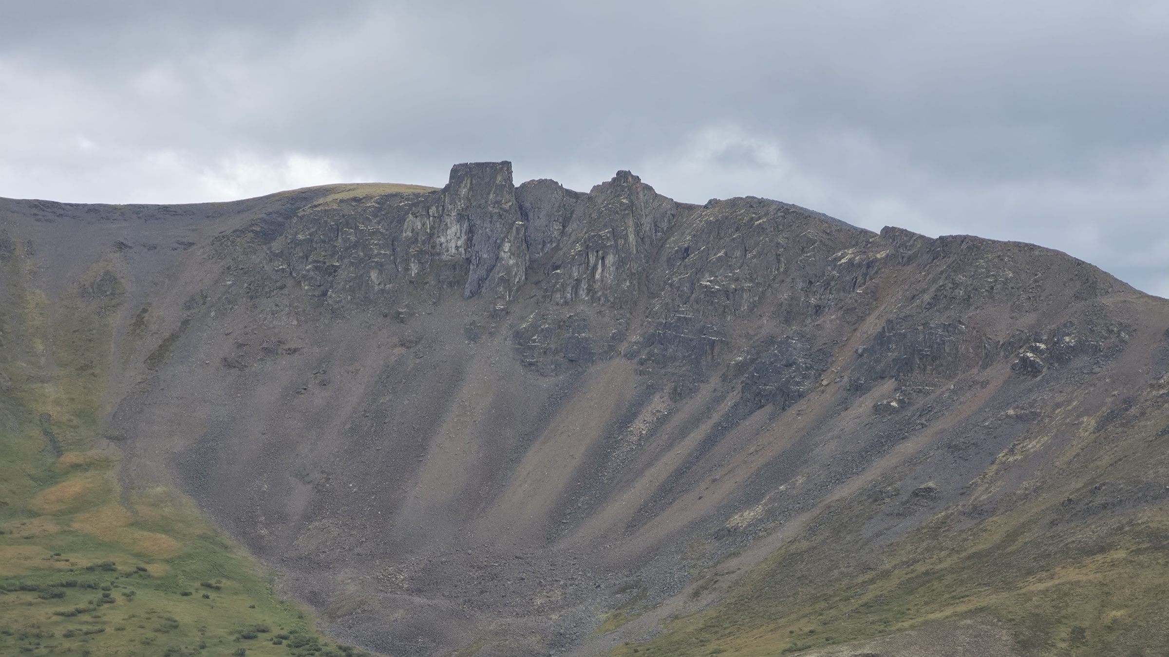 The opposing ridge rising sharply out of long scree slopes in dramatic relief.